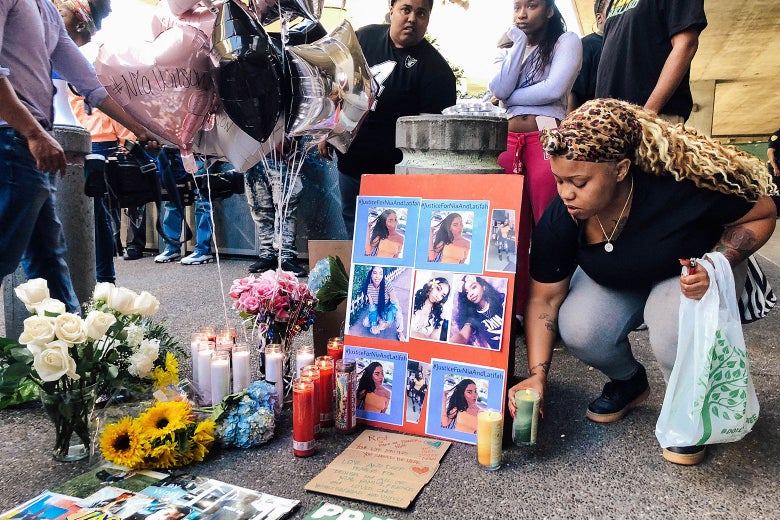 Malika Harris places a candle down for her sister Nia Wilson at a makeshift memorial.